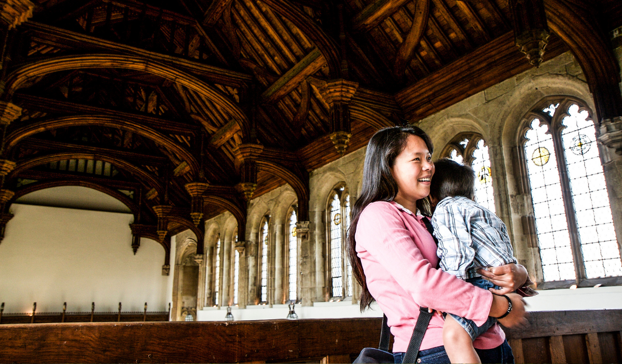 A woman and her child in the Great Hall at Eltham Palace.